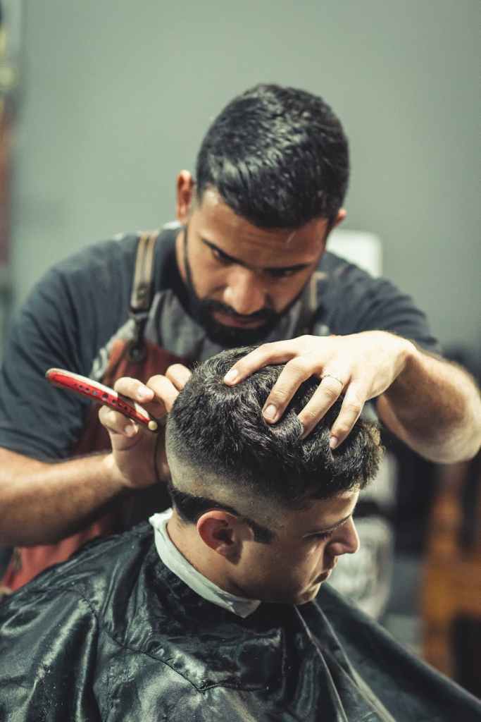 barber cutting person s hair