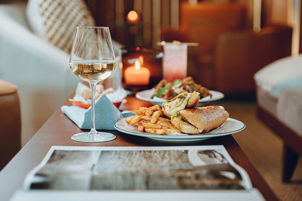 🪑 The Den at Hotel Lucine – A chic hotel-based coffee bar by day and cocktail lounge by night, serving freshly brewed drip coffee, specialty lattes, artisanal pastries, light bites like chicken bites & fries, and craft cocktails in a laid-back Seawall-front oasis.